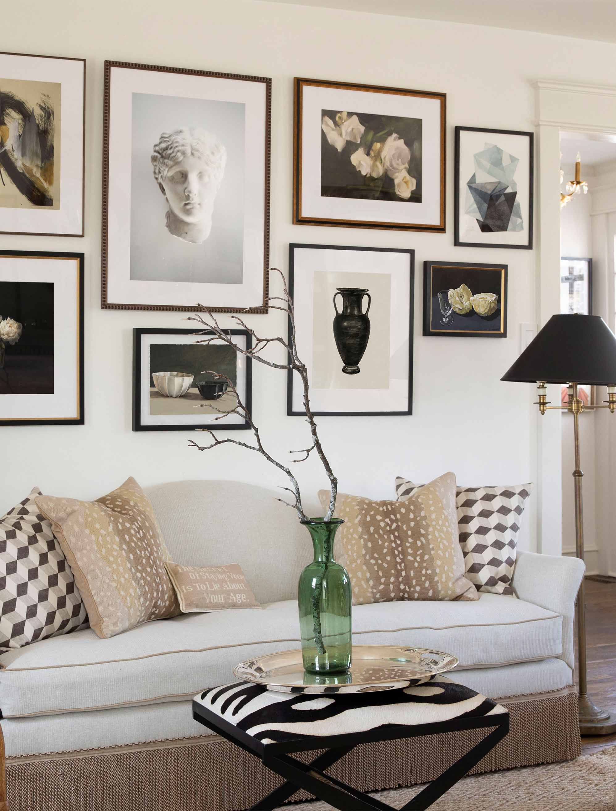 A large gallery wall makes a dramatic statement above a couch.